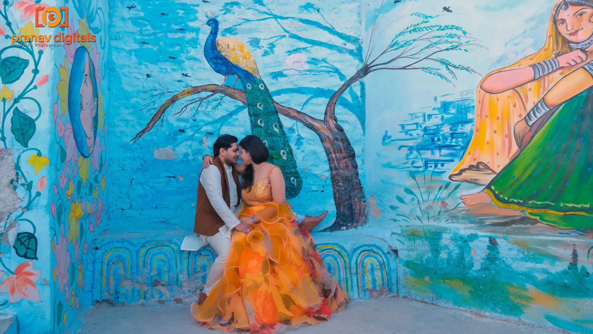 Couple posing in front of colorful wall mural in Jodhpur.